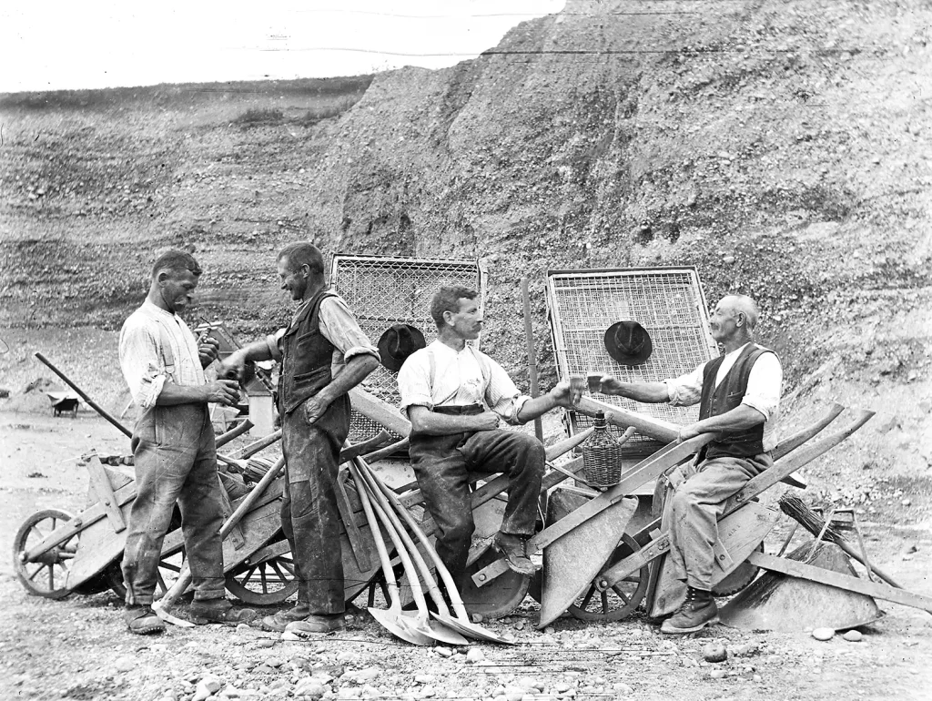 Feste, Feiern und Übergänge in Gossau Gruppe von Männern bei einer Arbeitspause mit Schoppen im Kieswerk
