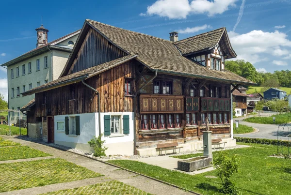 Das Dürstelerhaus in Unter-Ottikon (Gossau ZH) ist ein kulturhistorisches Fachwerkhaus und Museum. Seit 50 Jahren prägt es das Dorfleben mit Ausstellungen, Veranstaltungen und kulturellen Projekten. Das Bild zeigt die Hauptfassade des Hauses mit seiner traditionellen Architektur.