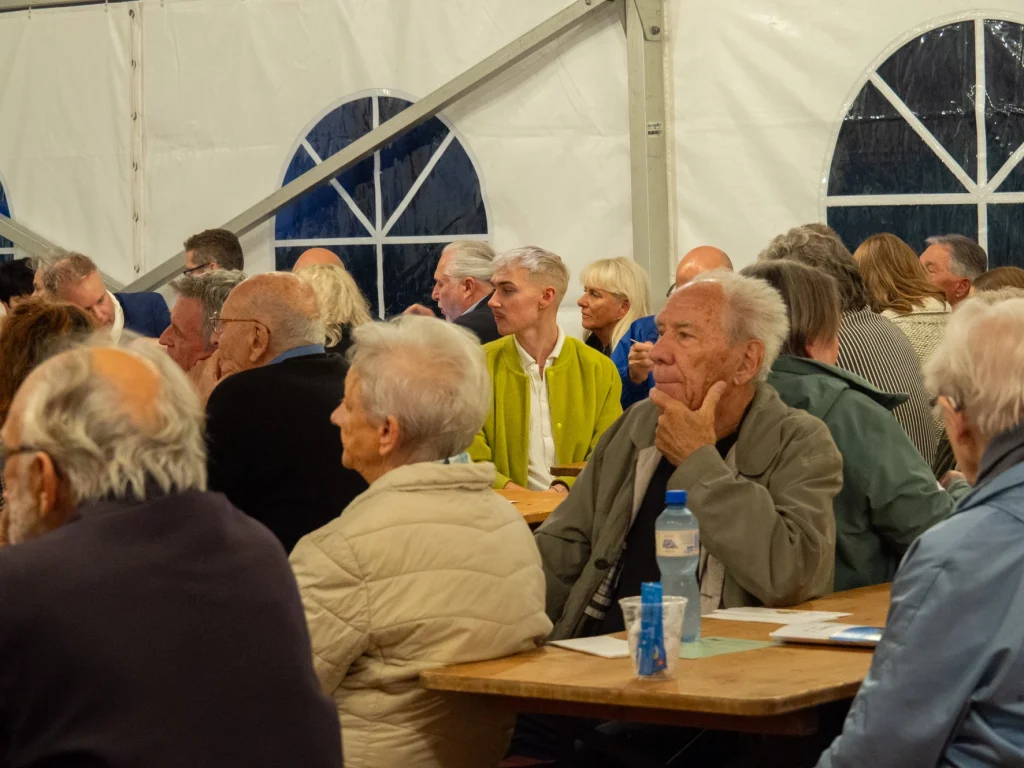 Das Publikum hört interessiert den Sprechern zu